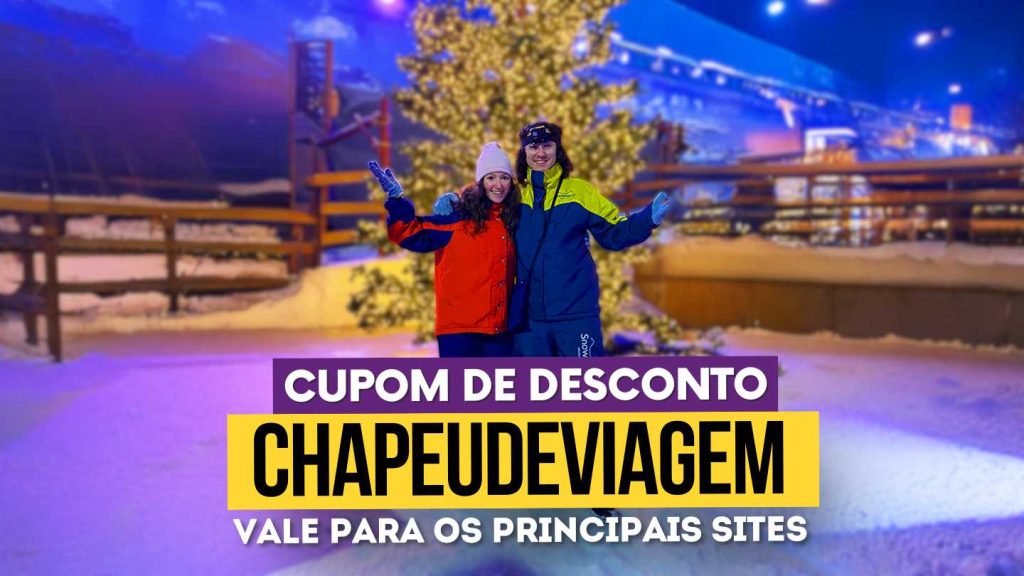Snowland Cupom CHAPEUDEVIAGEM - Andy e PH abraçados com as mãos apontando para os lados com trajes de neve