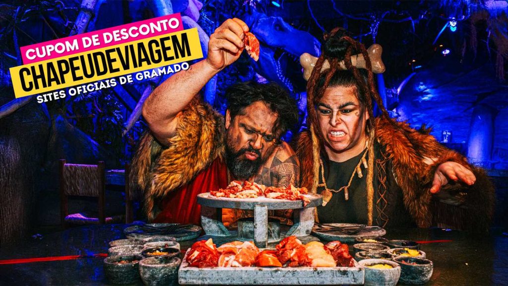 Cupom Era do Fogo Gramado - Vale a pena? Fondue 5% OFF 11 Cupom Era do Fogo CHAPEUDEVIAGEM - Personagens vestidos de homens das cavernas com fondue de carne na pedra