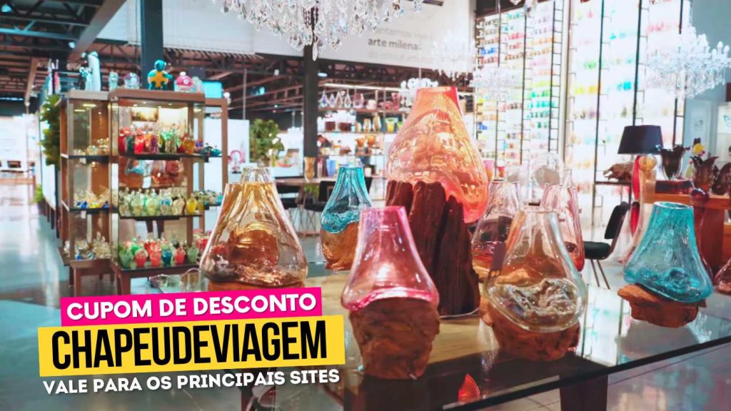 Cupom Cristais de Gramado CHAPEUDEVIAGEM - 10% de Desconto, Guia Completo 9 Cupom Cristais de Gramado CHAPEUDEVIAGEM - Vasos de Cristal coloridos em cima da mesa e visão da loja