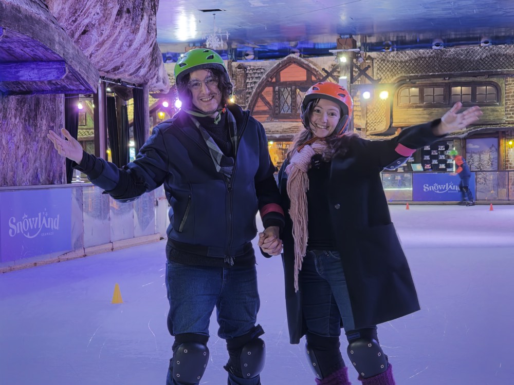 PH e Andy, do Chapéu de Viagem, sorrindo na pista de patinação no gelo do Snowland Gramado.